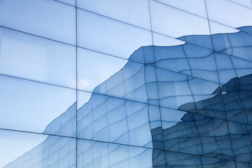 facade of modern glass building with reflections of blue sky and