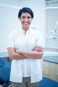 Smiling female dentist with arms crossed