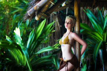 Young beautiful girl in a bamboo hut in a tropical jungle.