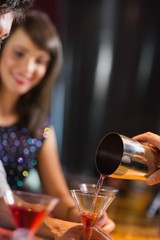 Bartender pouring cocktail for customers