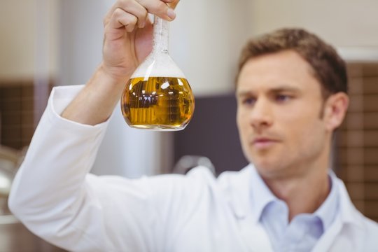 Focused scientist holding beaker with beer