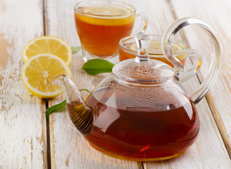 Hot  tea  and fresh lemon slices on  wooden table