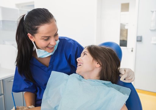 Cheerful pediatric dentist with a smiling young patient