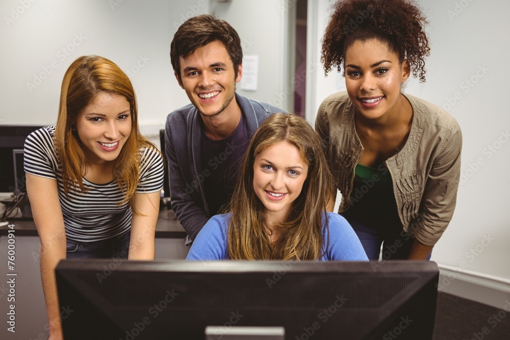 Poster Smiling students using computer together looking at camera