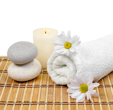 Spa decoration with stones, candle, towel and daisies