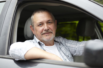 Mature Motorist Looking Out Of Car Window