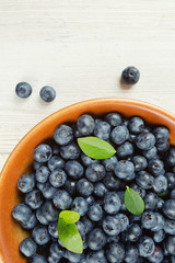 fresh blueberries in a bowl on wooden surface