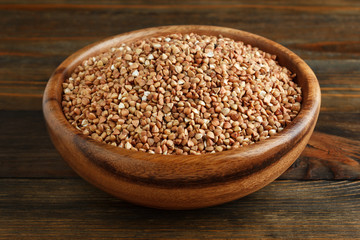Buckwheat in a wooden bowl on wood closeup