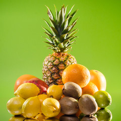 Still life pineapple and various fruits on green background