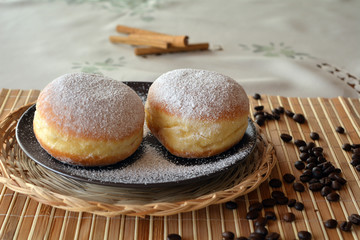 Donuts with powdered sugar on the brown plate