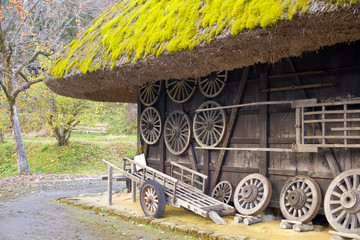 Obraz premium Wood hut with thatch roof and farmer tools