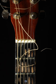 Guitar fretboard and head isolated on the dark background