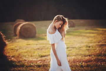 Obraz premium A beautiful blonde girl posing in a field on summer