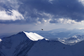 Off-piste slope for heliskiing and helicopter in evening