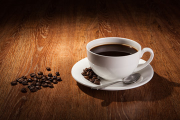 Still-life with a cup of black coffee and roasted coffee beans