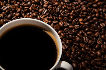 Still-life with a cup of black coffee and roasted coffee beans