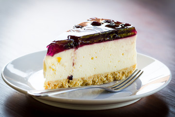Blueberry cheesecake in white plate on wood table