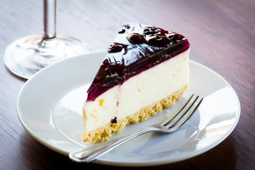 Blueberry cheesecake in white plate on wood table