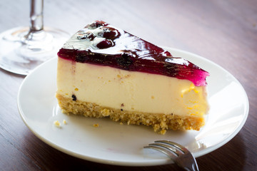 Blueberry cheesecake in white plate on wood table