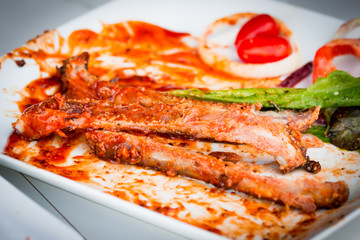 Bone of BBQ ribs after finished eating on dirty plate