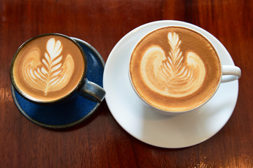 cup of latte art coffee on wooden background