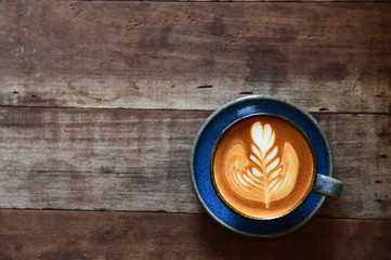 cup of latte art coffee on wooden background