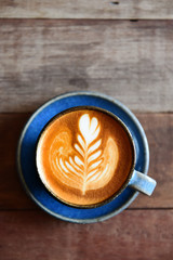cup of latte art coffee on wooden background