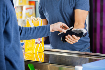 Man Using NFC Technology To Make Payment At Cinema