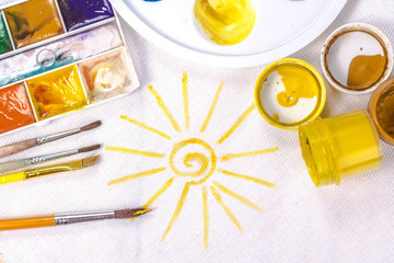 artist's brush on a background painted yellow sun