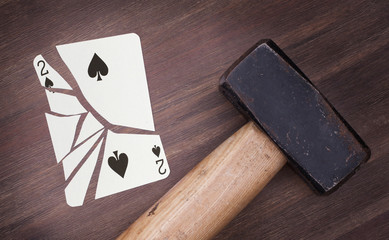 Hammer with a broken card, two of spades