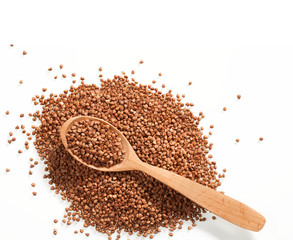 Heap of buckwheat groats and wooden spoon