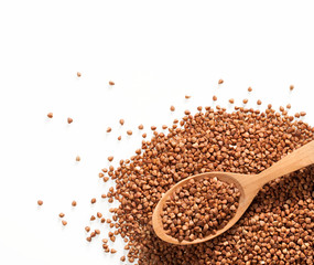 Heap of buckwheat groats and wooden spoon