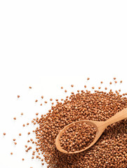 Heap of buckwheat groats and wooden spoon