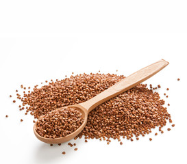 Wooden spoon on a heap of buckwheat groats