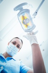 Fototapeta na wymiar Female dentist adjusting light