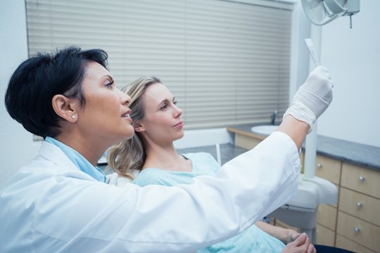 Female dentist showing woman her mouth x-ray