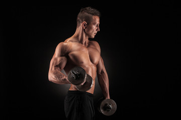 Muscular man with dumbbells on black background
