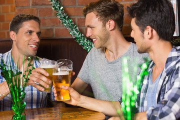 Happy friends toasting with pints of beer on patricks day