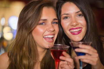 Pretty friends drinking cocktails together