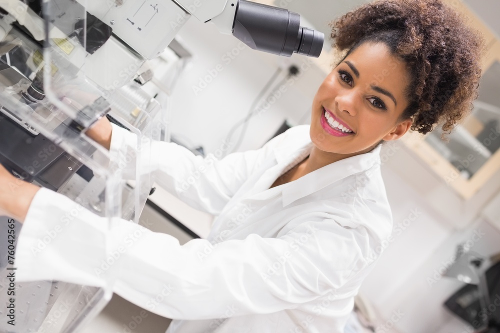 Wall mural pretty science student using microscope