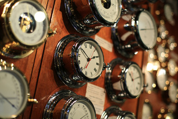 Shiny steel clock on the wall of wood