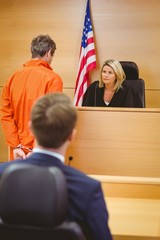 Judge and criminal speaking in front of the american flag