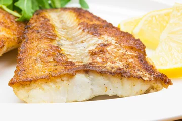 Tableaux ronds sur aluminium Poisson White fish with lemon on white plate