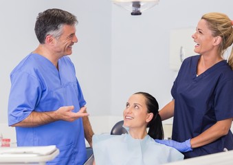 Fototapeta premium Smiling dentist and nurse speaking with their patient