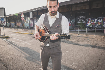 handsome big moustache hipster man playing mandolin