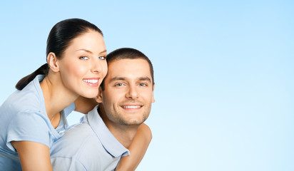 Cheerful young couple, over blue
