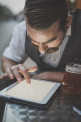 handsome big moustache hipster man using tablet