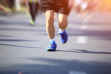 marathon athletes legs running on city road