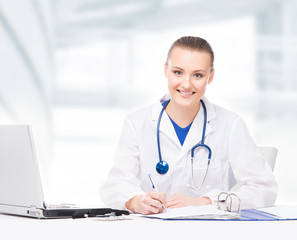 Young, professional and cheerful female doctor working in office