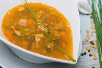 lentil soup with chorizo and vegetables on a wooden table